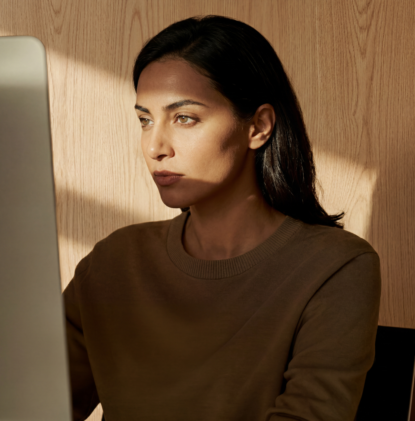 A focused professional working at a computer, managing payroll for their team