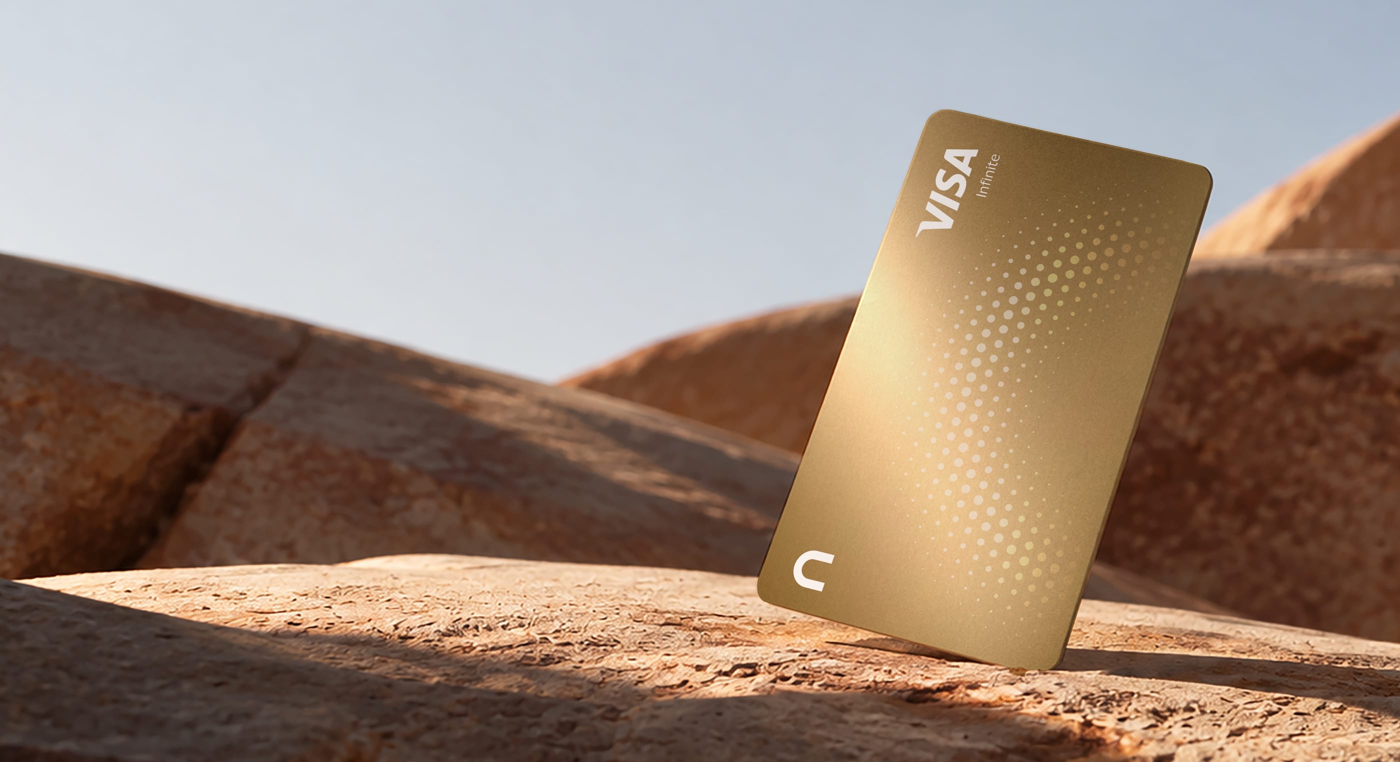 Gold nsave Visa Infinite card standing in desert sand
