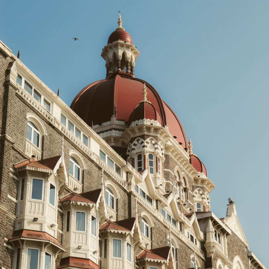 Ornate heritage hotel with red domes against a clear blue sky