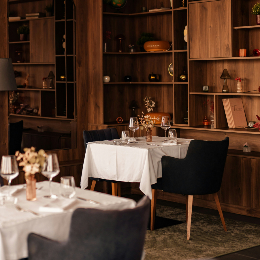 Restaurant dining room with set tables in front of wooden shelving
