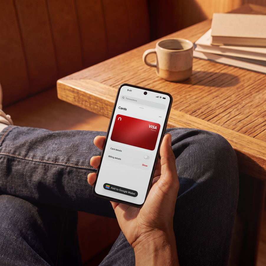 Hand holding a phone showing the red nsave Visa card in a mobile wallet